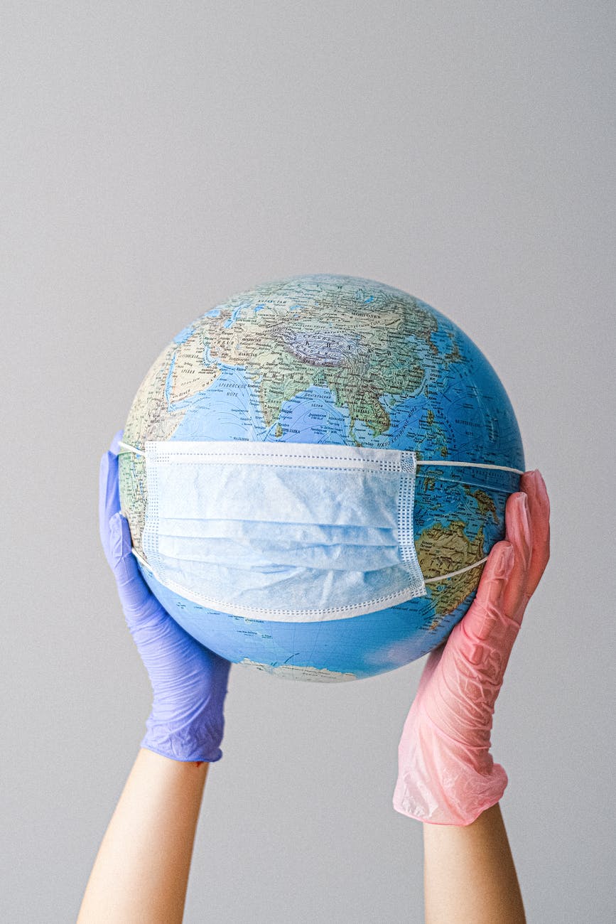 pexels-photo-4167544 hands with latex gloves holding a globe with a face mask